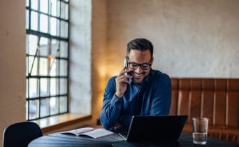 Busy man working at his office while making a phone call and smile