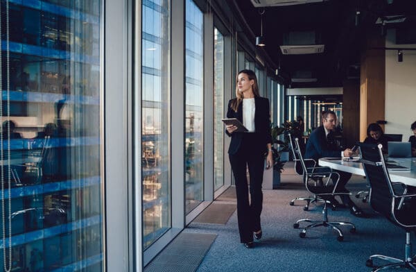 Serious female administrative manager in formal suit walking in